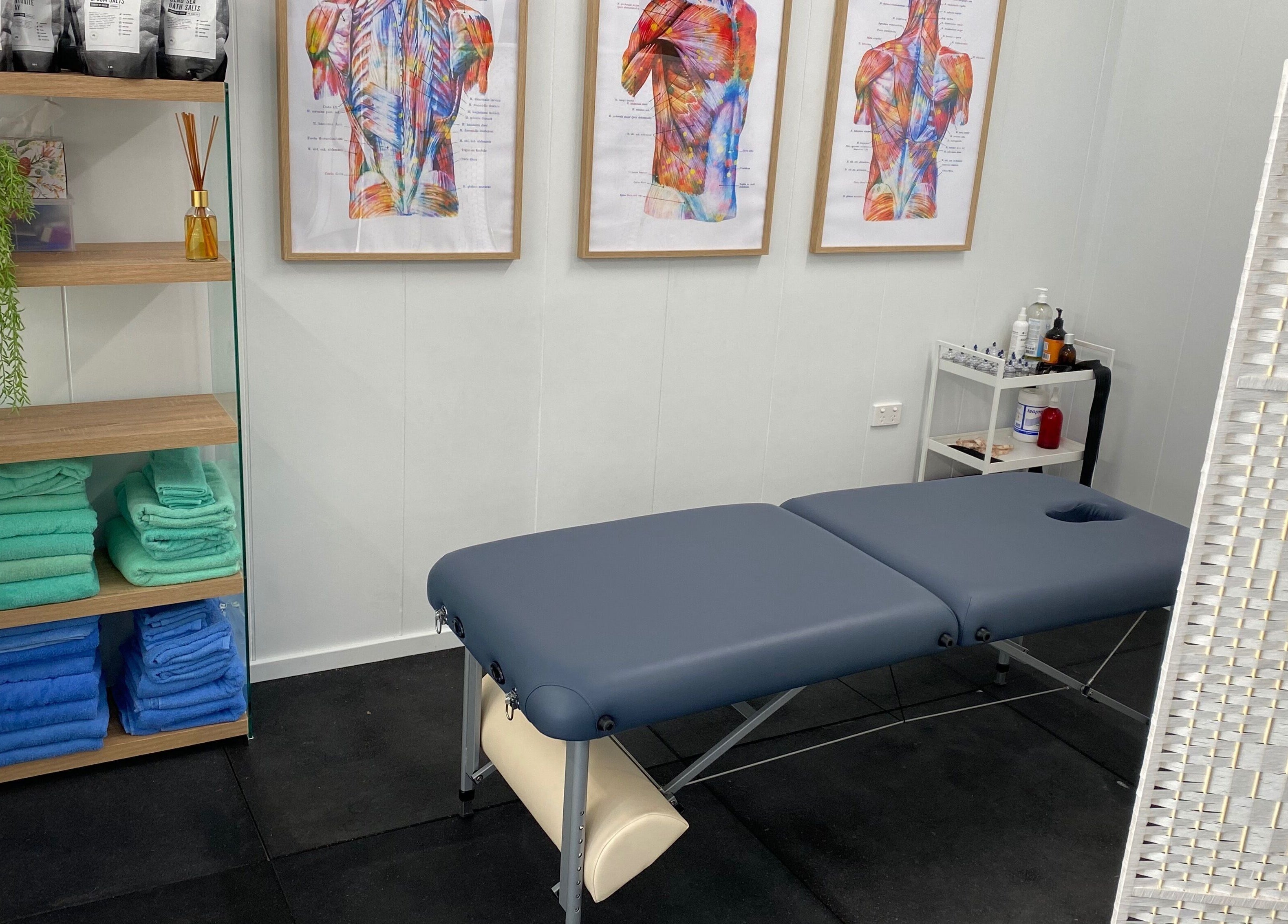 Massage room at Proform Coaching and Massage, Singleton, New South Wales, AU with a table and vibrant anatomical art.