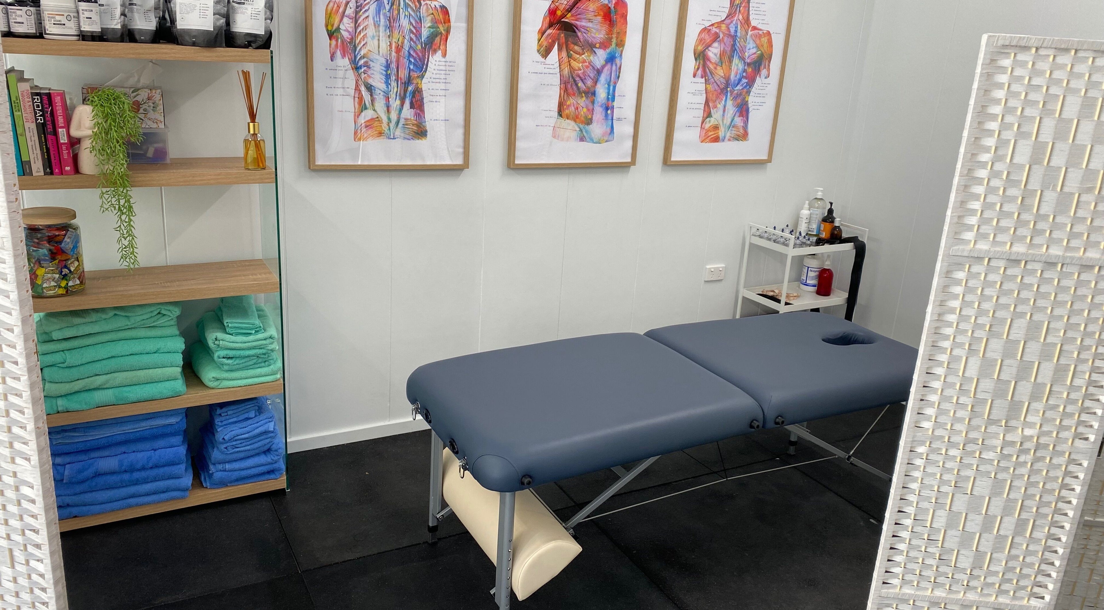 Massage room at Proform Coaching and Massage, Singleton, New South Wales, AU with a table and vibrant anatomical art.