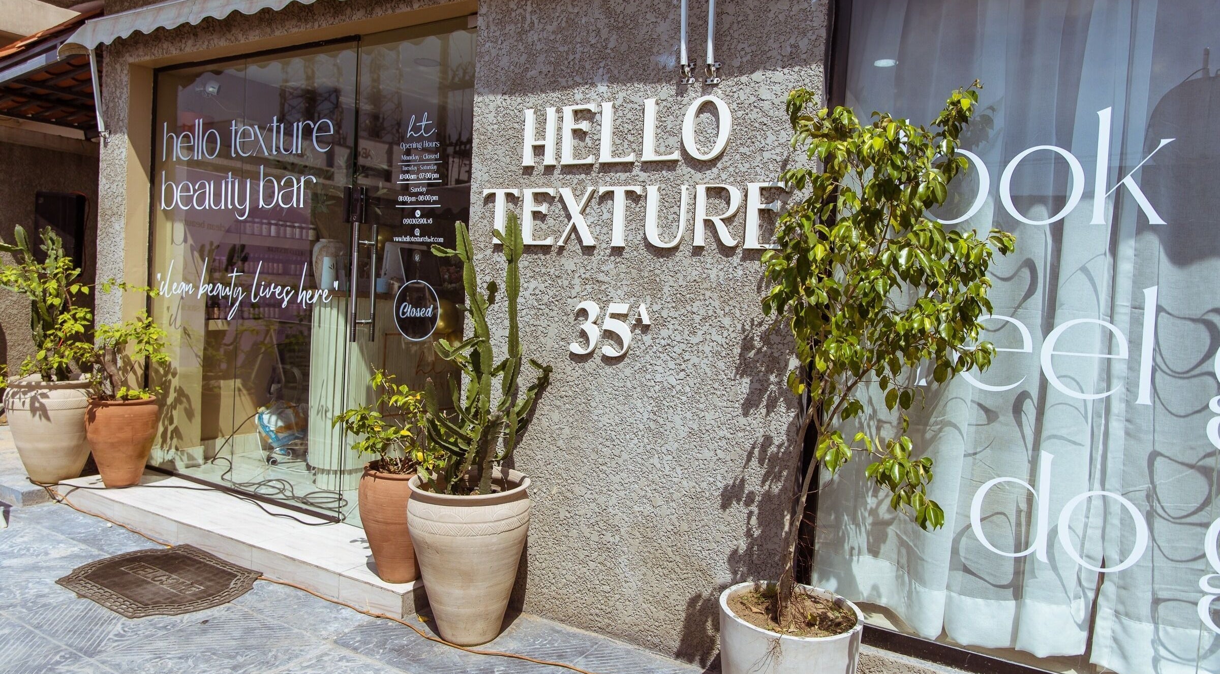 Front view of Hello Texture beauty bar in Lekki, Lagos, NG, showcasing potted plants and modern decor.