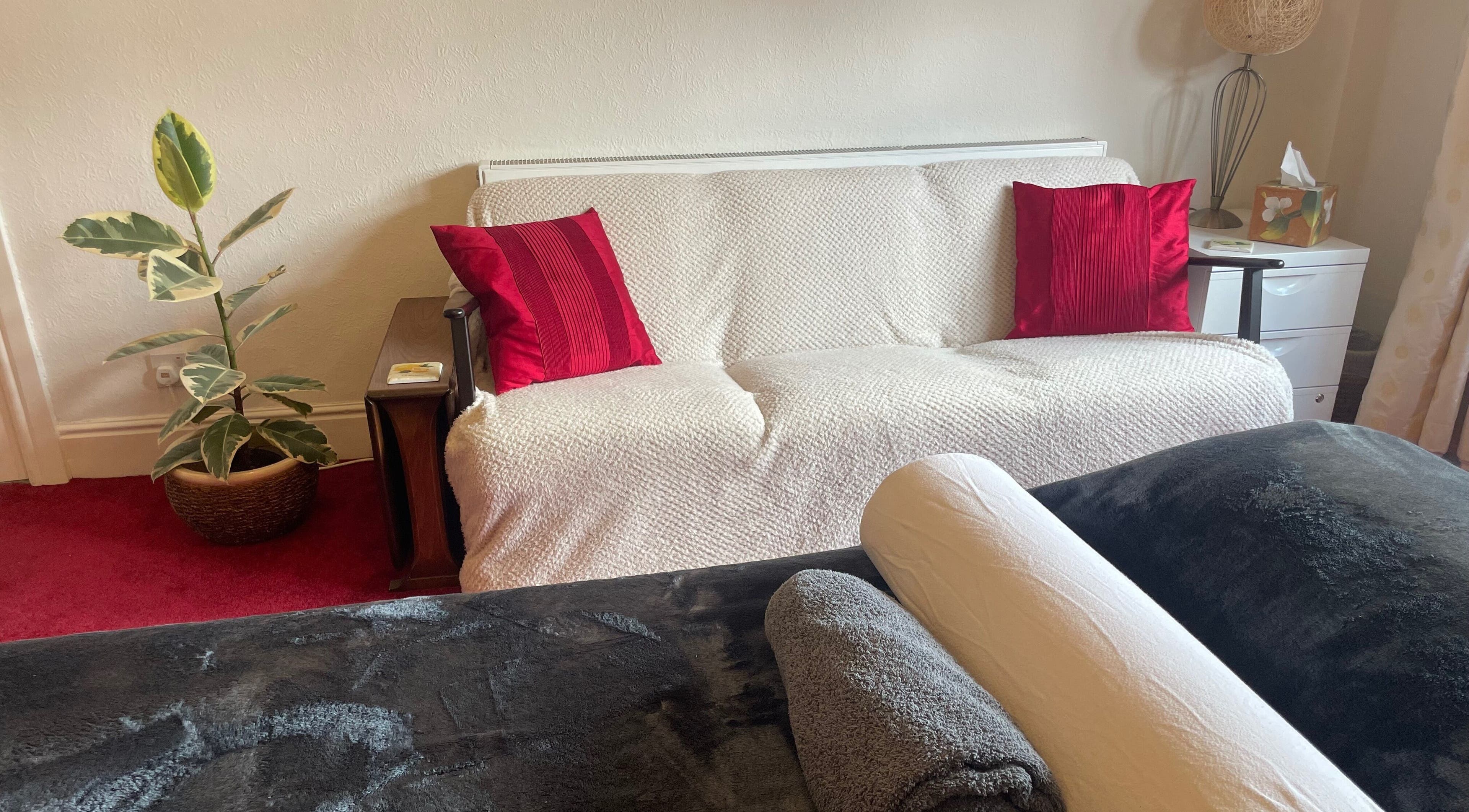 Comfortable therapy room at Leamington Therapy, Royal Leamington Spa, England, with plush sofa and decor.