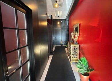 Elegant hallway at OrientalBay Amarin Thai Massage & Spa, Wellington, NZ with red decor and golden accents.