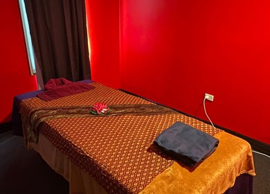 Massage room at Miramar 🌸 Amarin Thai Balinese Massage & Spa, Wellington, NZ with red walls and a prepared massage bed.