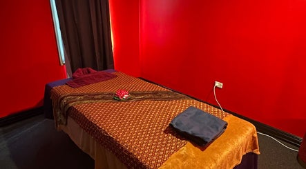 Massage room at Miramar 🌸 Amarin Thai Balinese Massage & Spa, Wellington, NZ with red walls and a prepared massage bed.