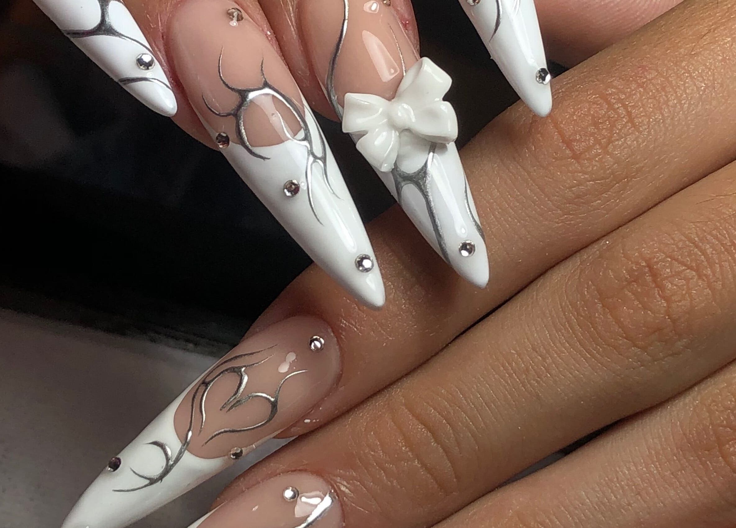 Decoración de uñas elegante en Meloody Nails, Cali, Valle Del Cauca, CO con detalles en blanco y lazo.