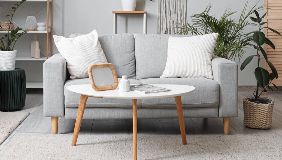 Salon moderne à Acha Home Service spa, Dubai, Dubai, AE avec canapé gris et plantes vertes.