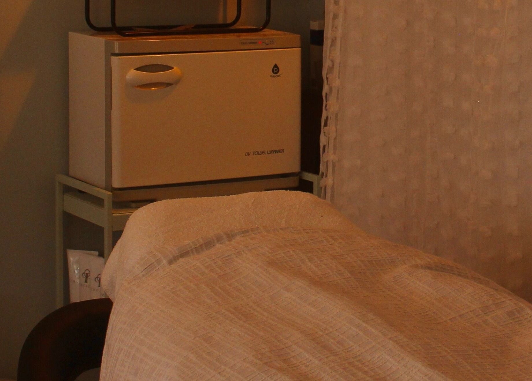 Massage table at Reach Medspa & Manicures, Mississauga, Ontario, CA, offering a tranquil relaxation experience.