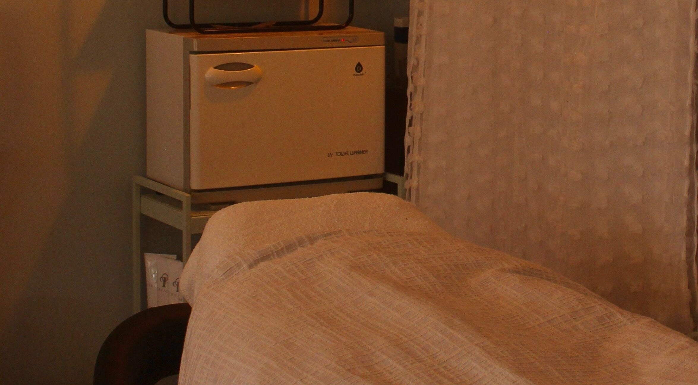 Massage table at Reach Medspa & Manicures, Mississauga, Ontario, CA, offering a tranquil relaxation experience.