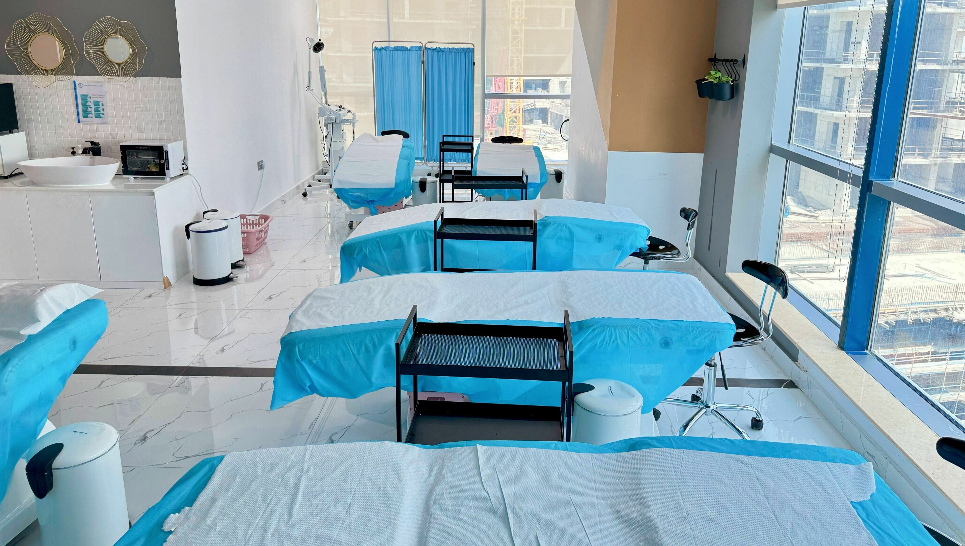 Bright treatment room with blue-draped beds at Sunface Medical Aesthetic Center, Dubai, Dubai, AE.