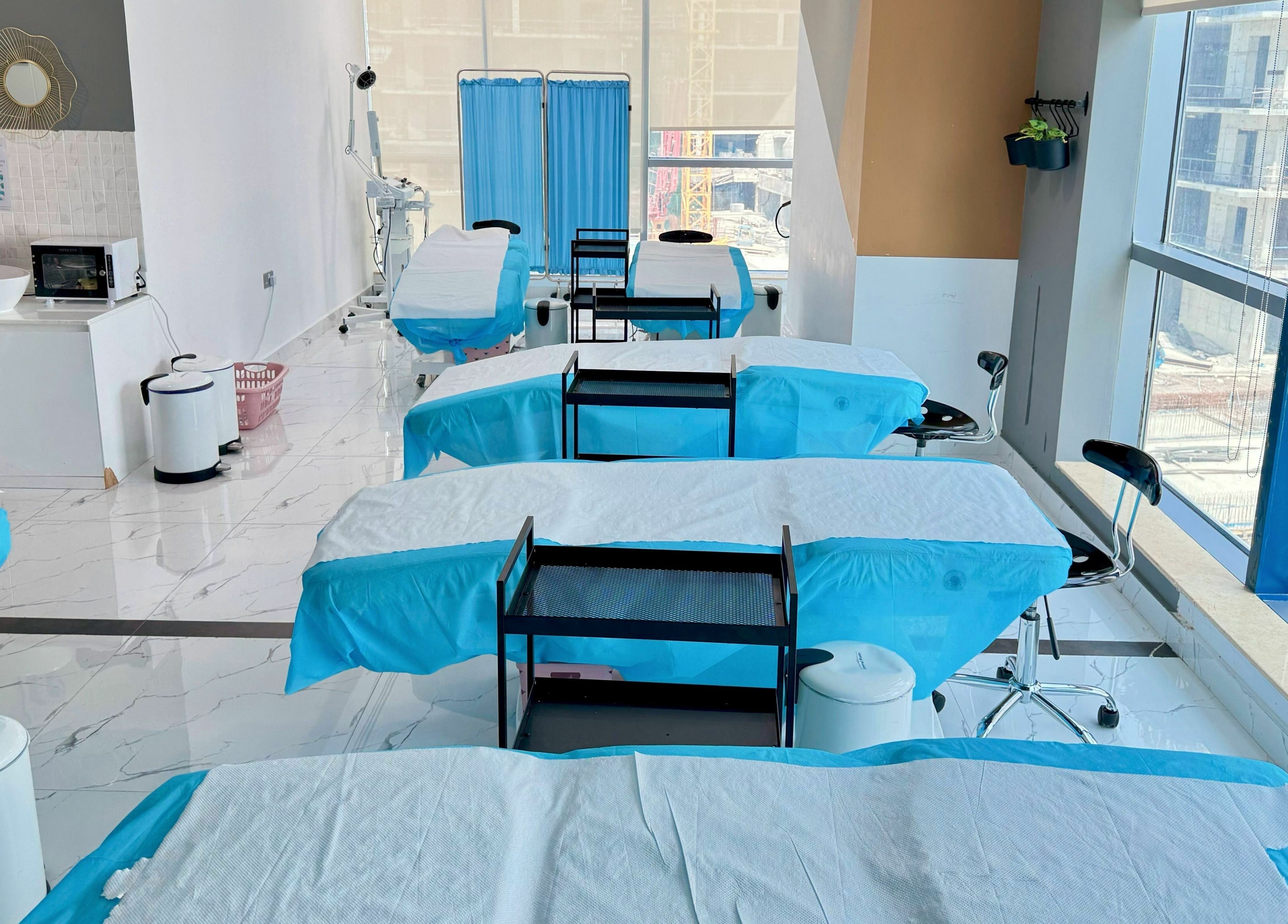 Bright treatment room with blue-draped beds at Sunface Medical Aesthetic Center, Dubai, Dubai, AE.