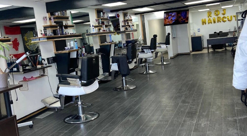Modern interior of R Ojhaircut in Kitchener, Ontario, CA with chic salon chairs and mirrors.