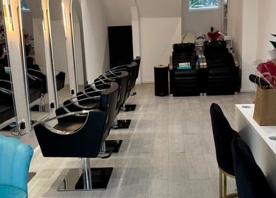 Elegant interior of S&M Beauty Lounge, London, England, showcasing modern styling chairs and mirrors.