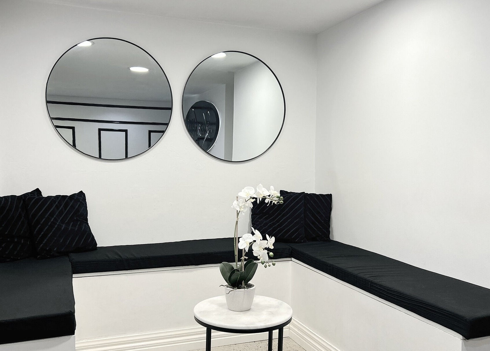 Modern lounge with black seating and orchids at Lash Envy | Berwick, Berwick, VIC, AU.