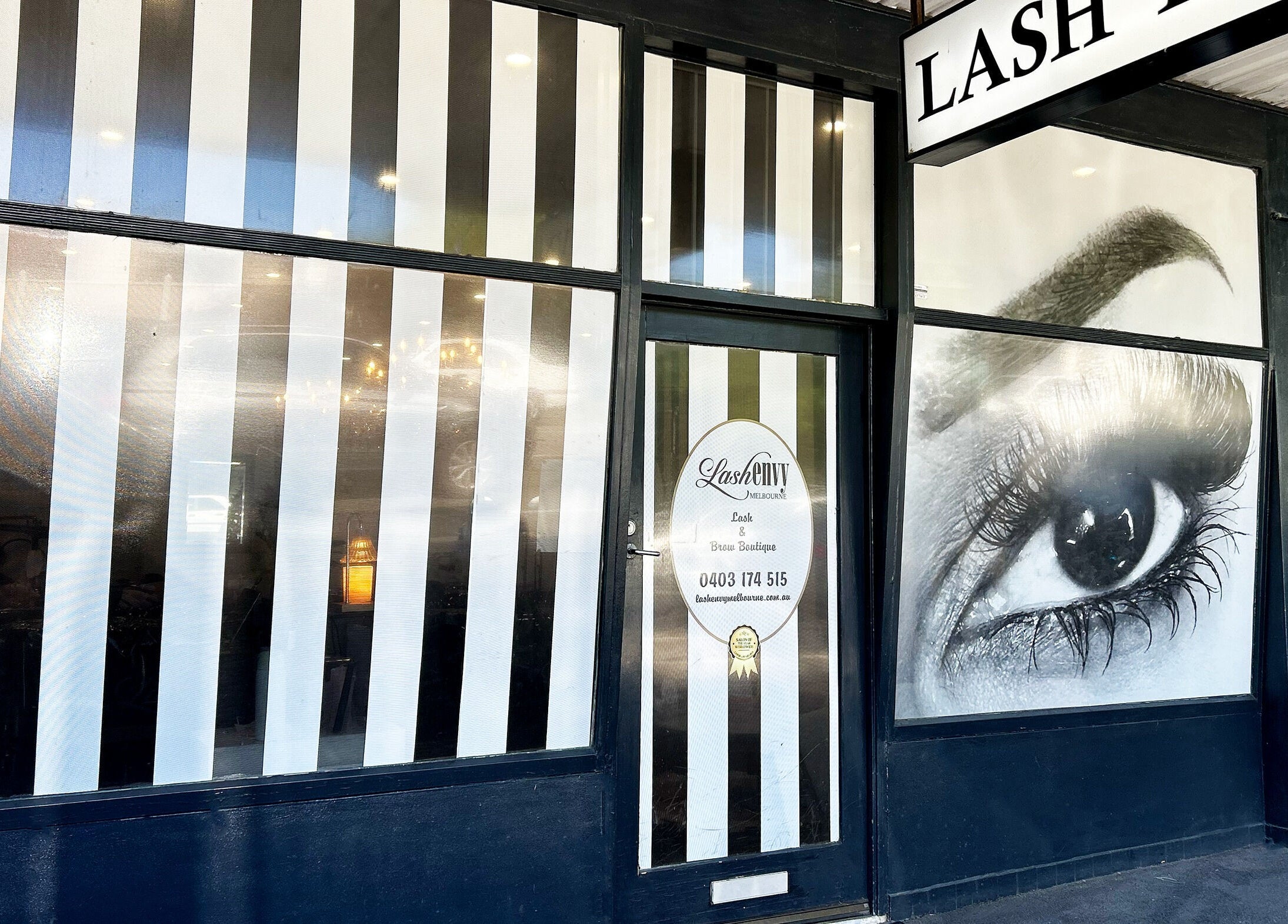 Exterior of Lash Envy in Hampton, VIC, AU with stylish striped design and eye graphic.