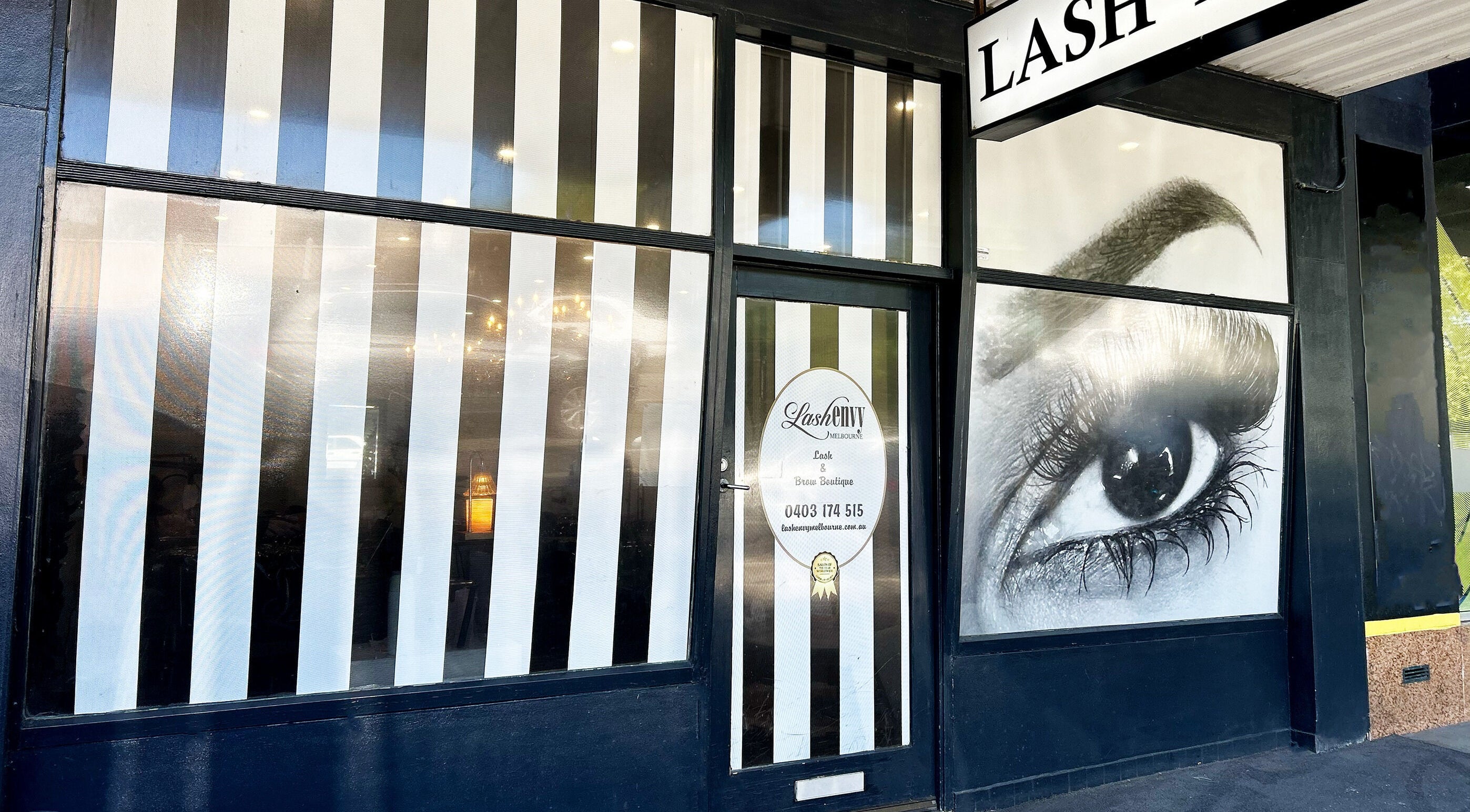 Exterior of Lash Envy in Hampton, VIC, AU with stylish striped design and eye graphic.