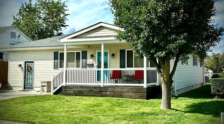 Charming white house facade with porch at SeptemberS Salon - Nitro, Nitro, West Virginia, US.
