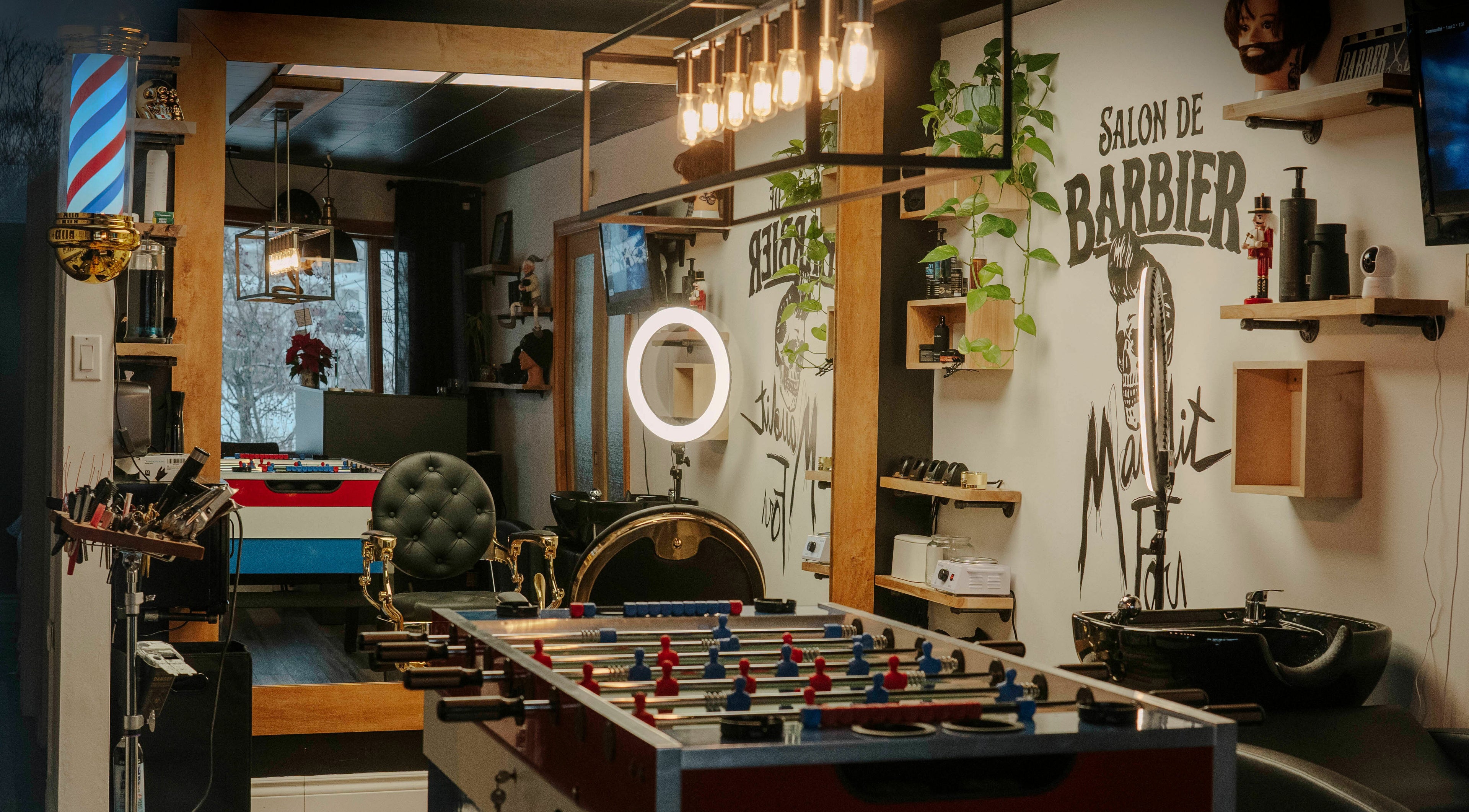 Intérieur du Salon de Barbier Maudit Fou Barbershop à Mont-joli, Québec, CA avec table de baby-foot.