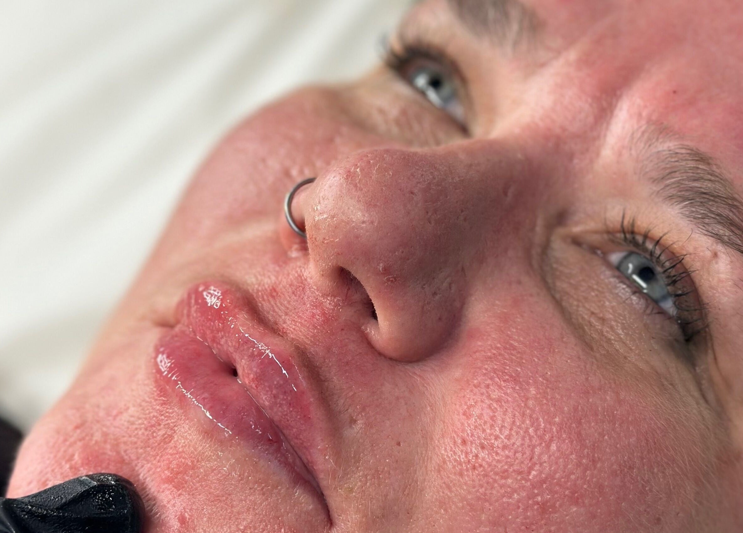 Close-up of a woman's radiant face post-treatment at PRETTY LITTLE FACES, Desborough, England, GB.