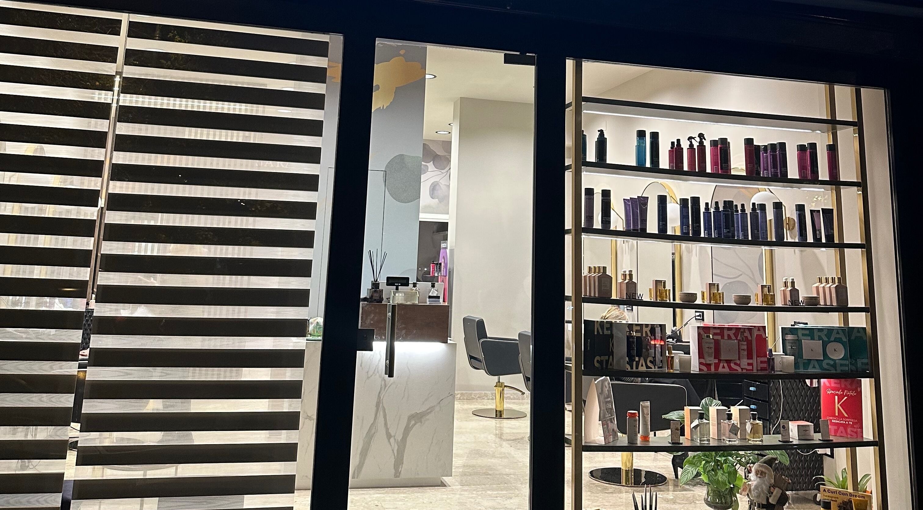 Vista notturna della vetrina di SaraAles a Palermo, Sicilia, IT, con prodotti di bellezza in esposizione.