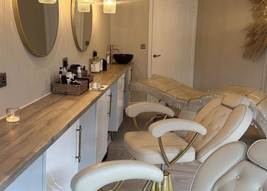 Chic treatment area at Eye Love Brows, Glasgow, Scotland, GB featuring plush chairs and ambient lighting.