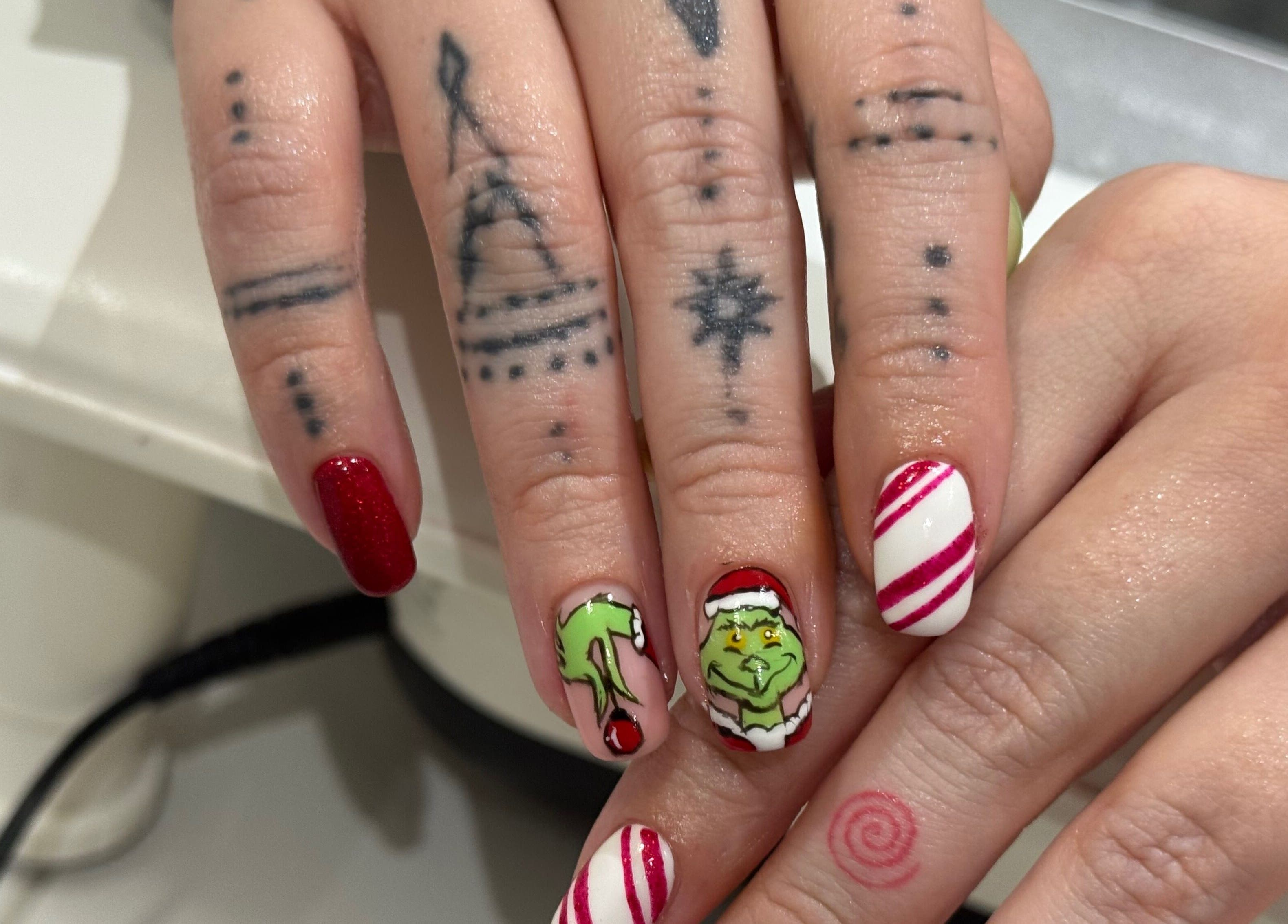 Creative Grinch-themed nail art at AP Beauty in Ayr, Scotland, GB, featuring red and white festive designs.