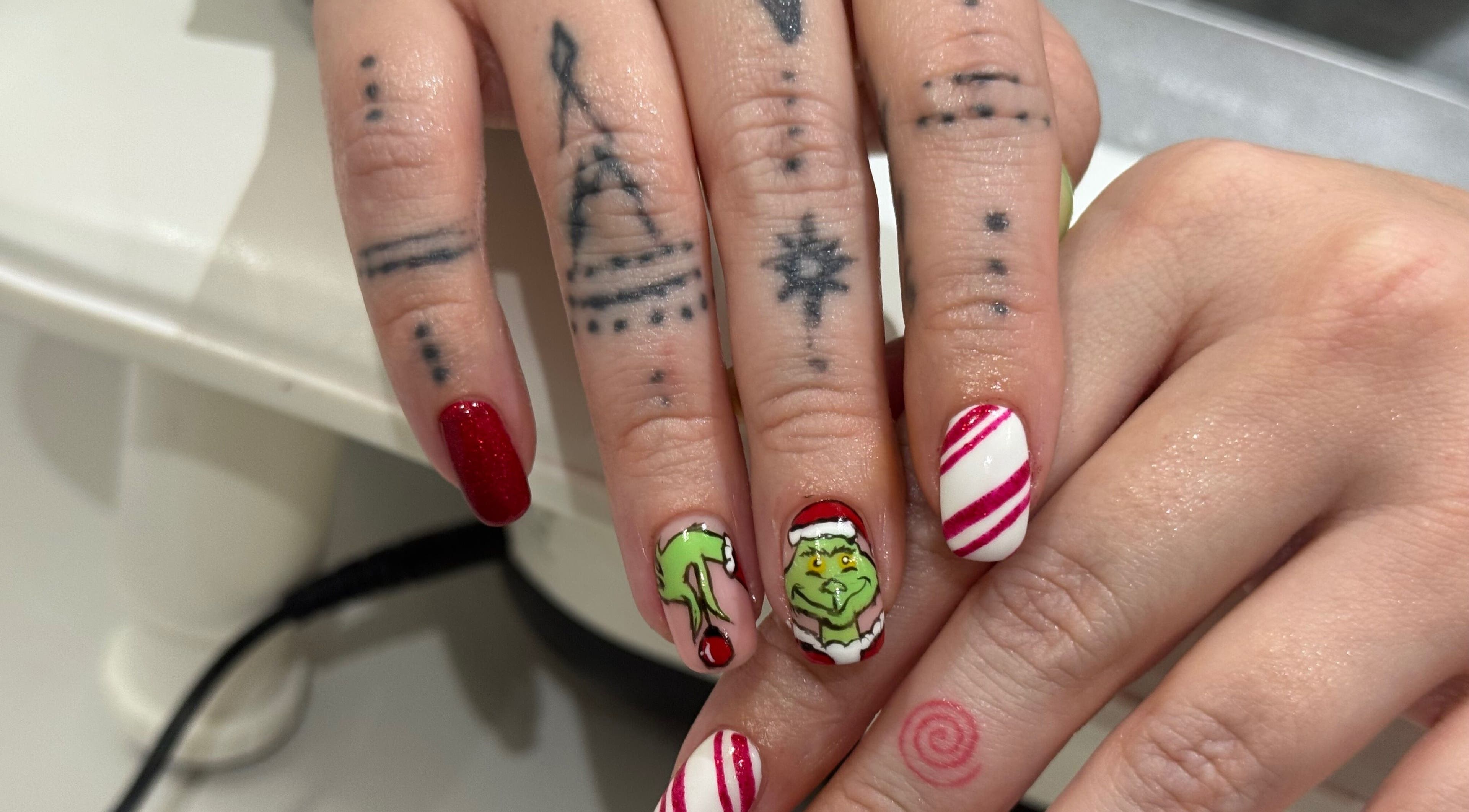 Creative Grinch-themed nail art at AP Beauty in Ayr, Scotland, GB, featuring red and white festive designs.