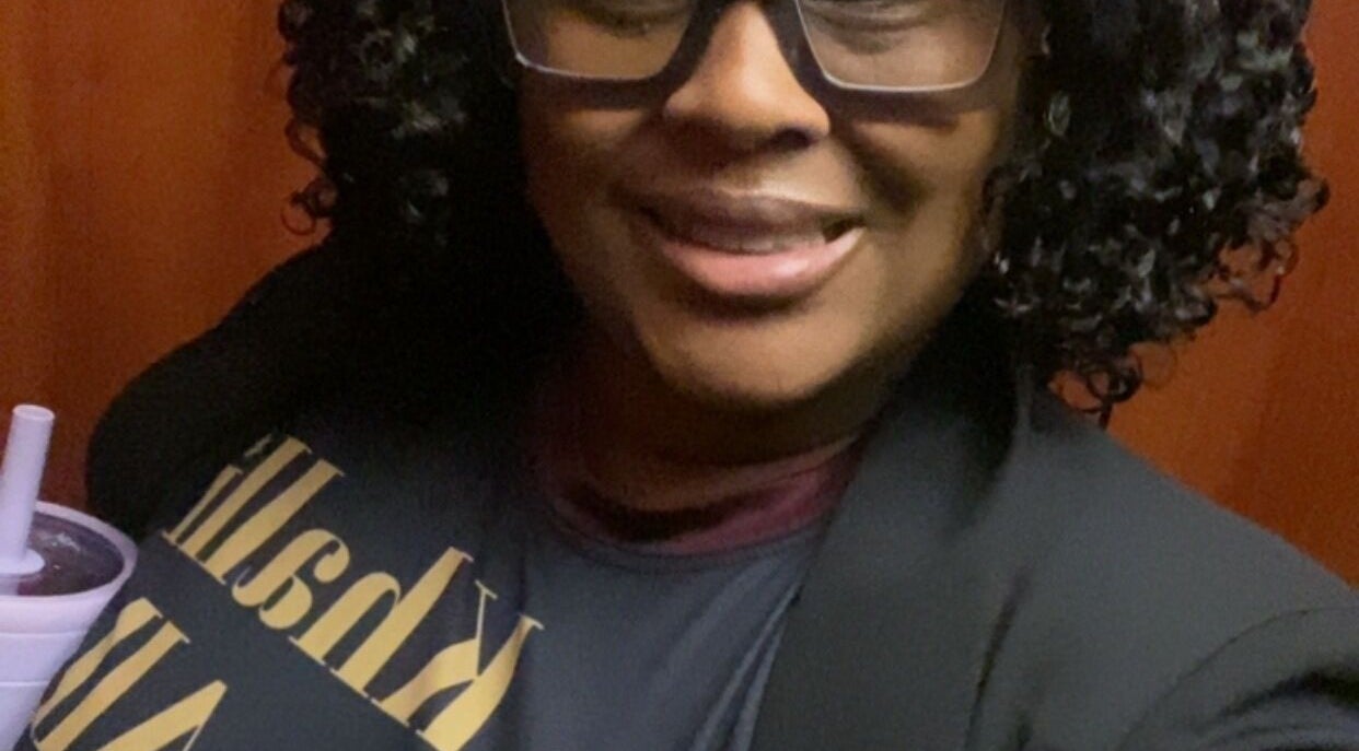 A smiling person in glasses at Khallin All Kurls Natural Kinks, New Port Richey, Florida, US.