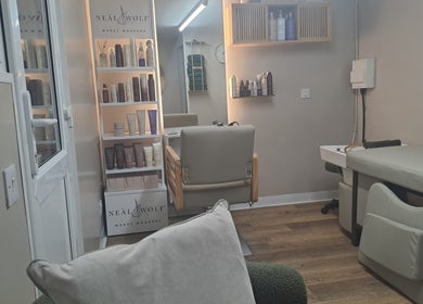 Interior of The Hair Cabin in Featherstone, England, GB, featuring salon chair and beauty products shelf.