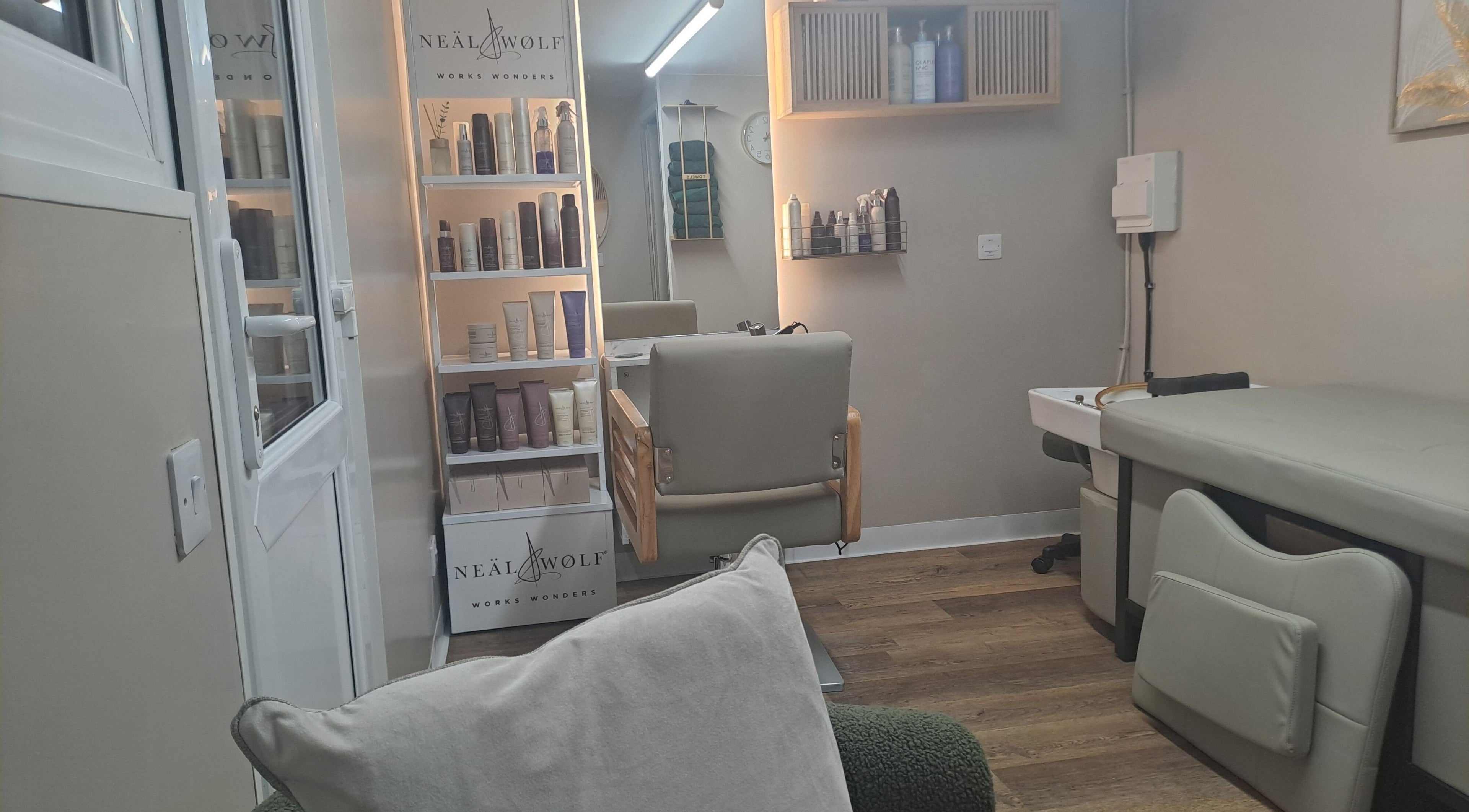 Interior of The Hair Cabin in Featherstone, England, GB, featuring salon chair and beauty products shelf.