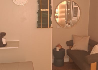 Inviting relaxation corner in The Hair Cabin, Featherstone, England, GB with comfy seating and a towel rack.