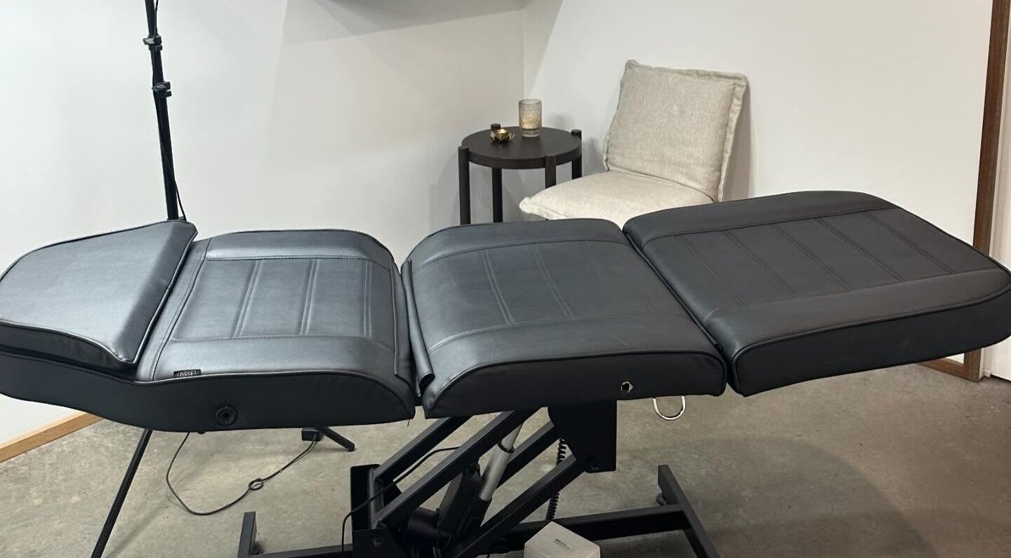 Treatment room at Feather and Arch Cosmetic Tattoo, Mooloolaba, Queensland, AU with an adjustable black chair.