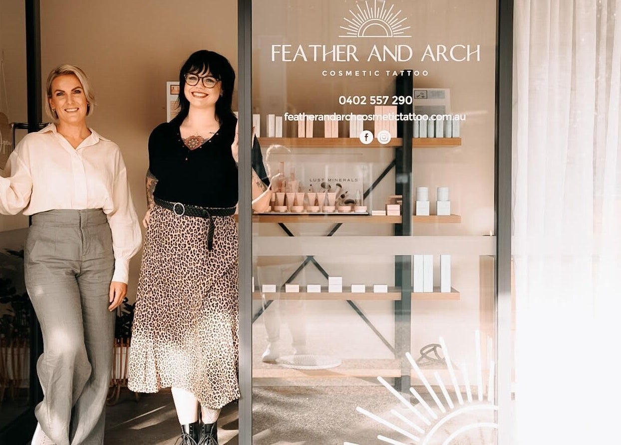 Inside view of Feather and Arch Cosmetic Tattoo in Mooloolaba, Queensland, AU with smiling staff by entrance.
