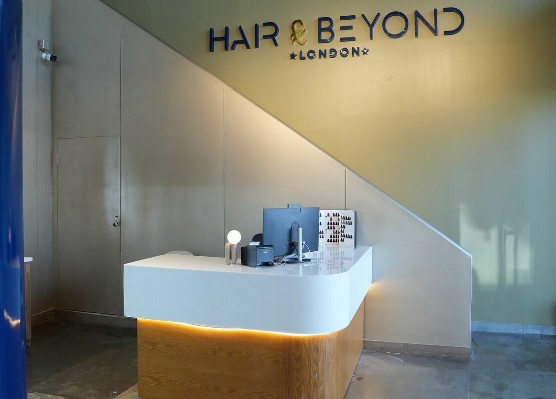 Sleek reception desk at The Hair and Beyond Salon, Jeddah, Makkah Province, SA with elegant lighting.