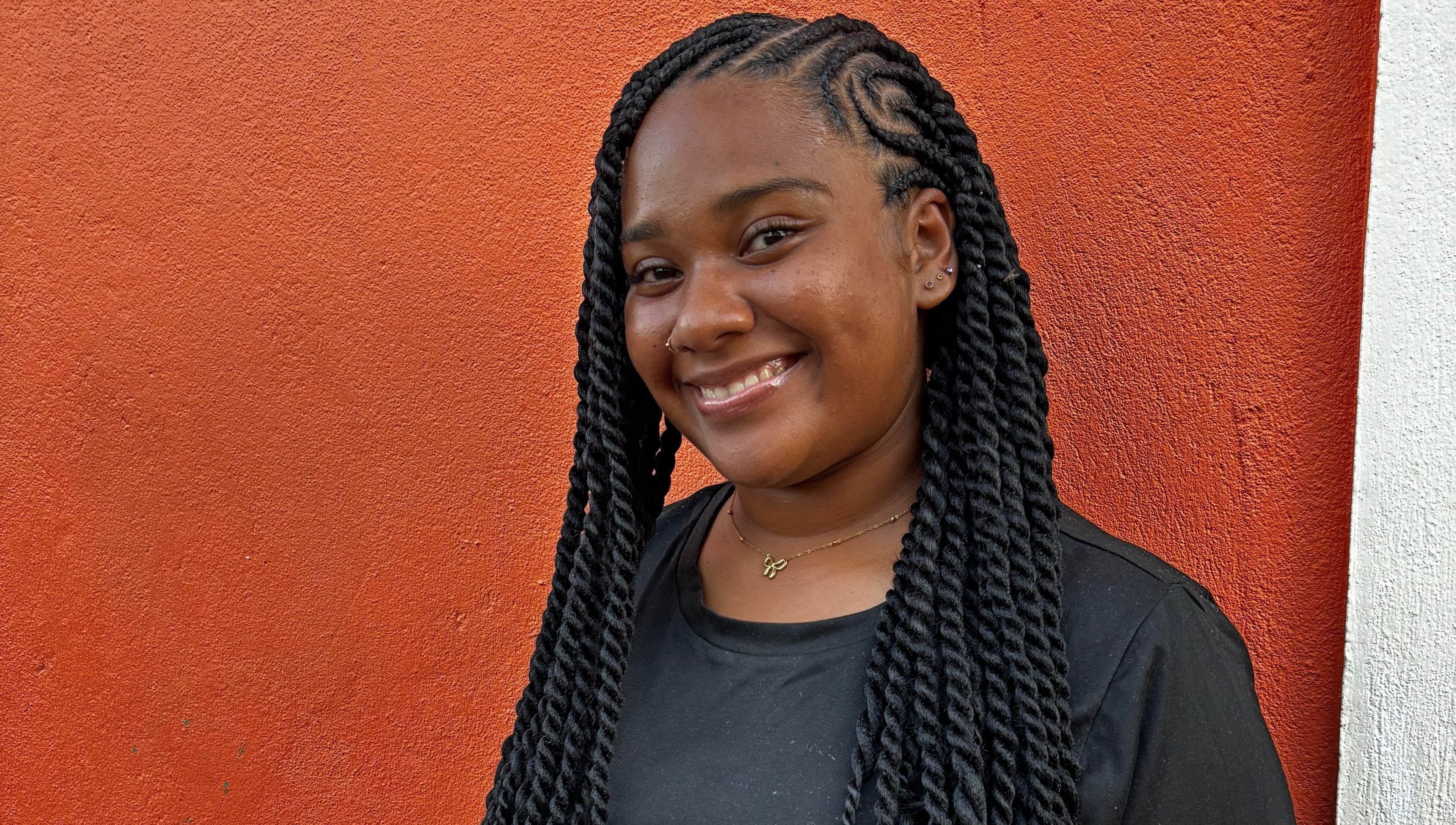 Smiling woman with braided hairstyle at Strands of Beauty, Georgetown, Demerara-mahaica, GY.