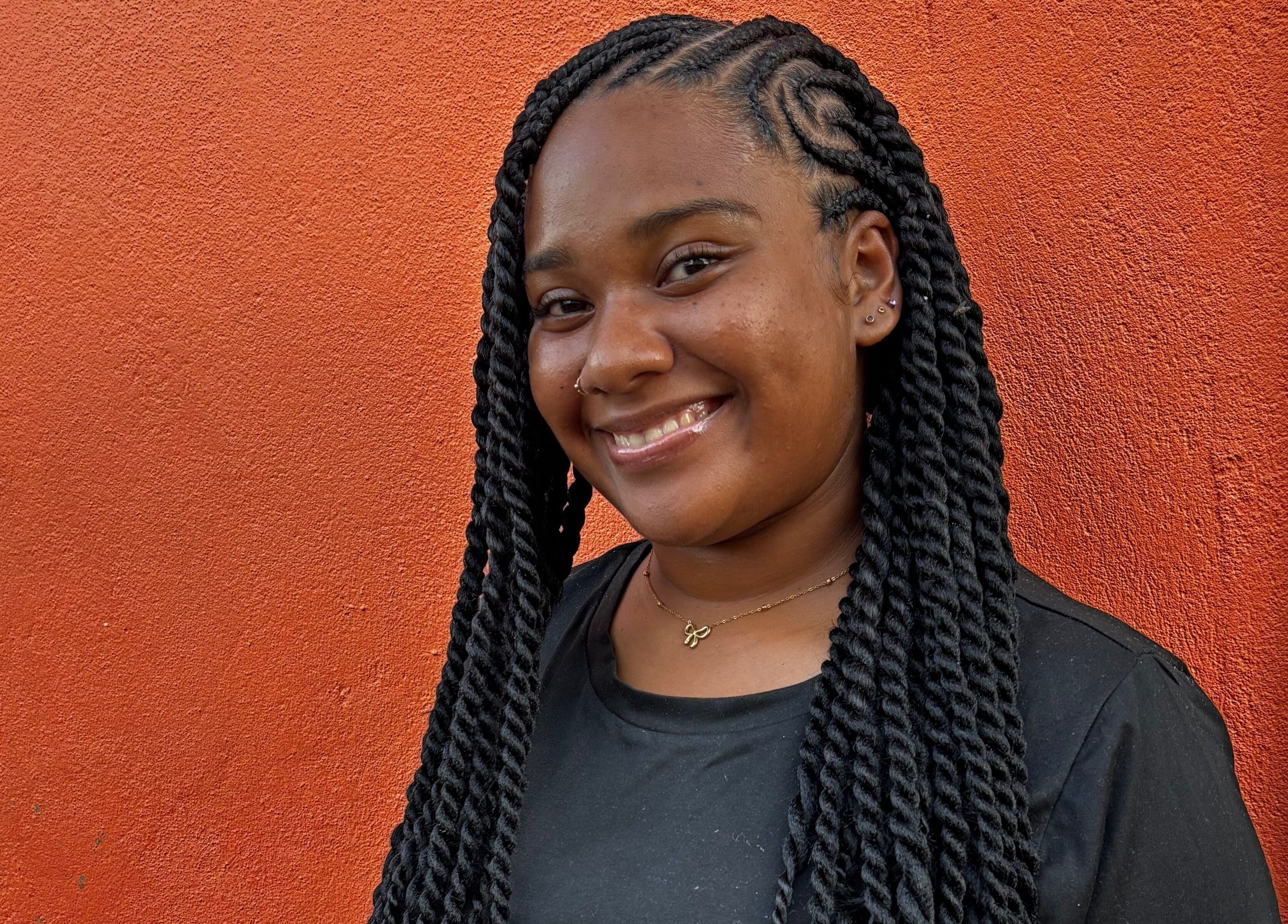 Smiling woman with braided hairstyle at Strands of Beauty, Georgetown, Demerara-mahaica, GY.