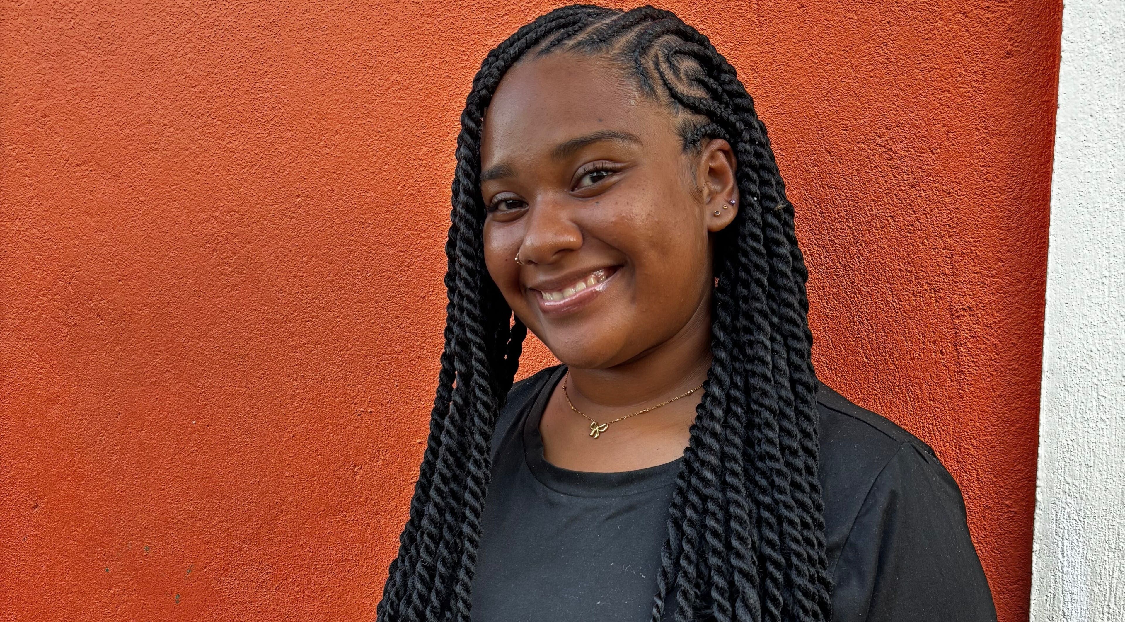 Smiling woman with braided hairstyle at Strands of Beauty, Georgetown, Demerara-mahaica, GY.