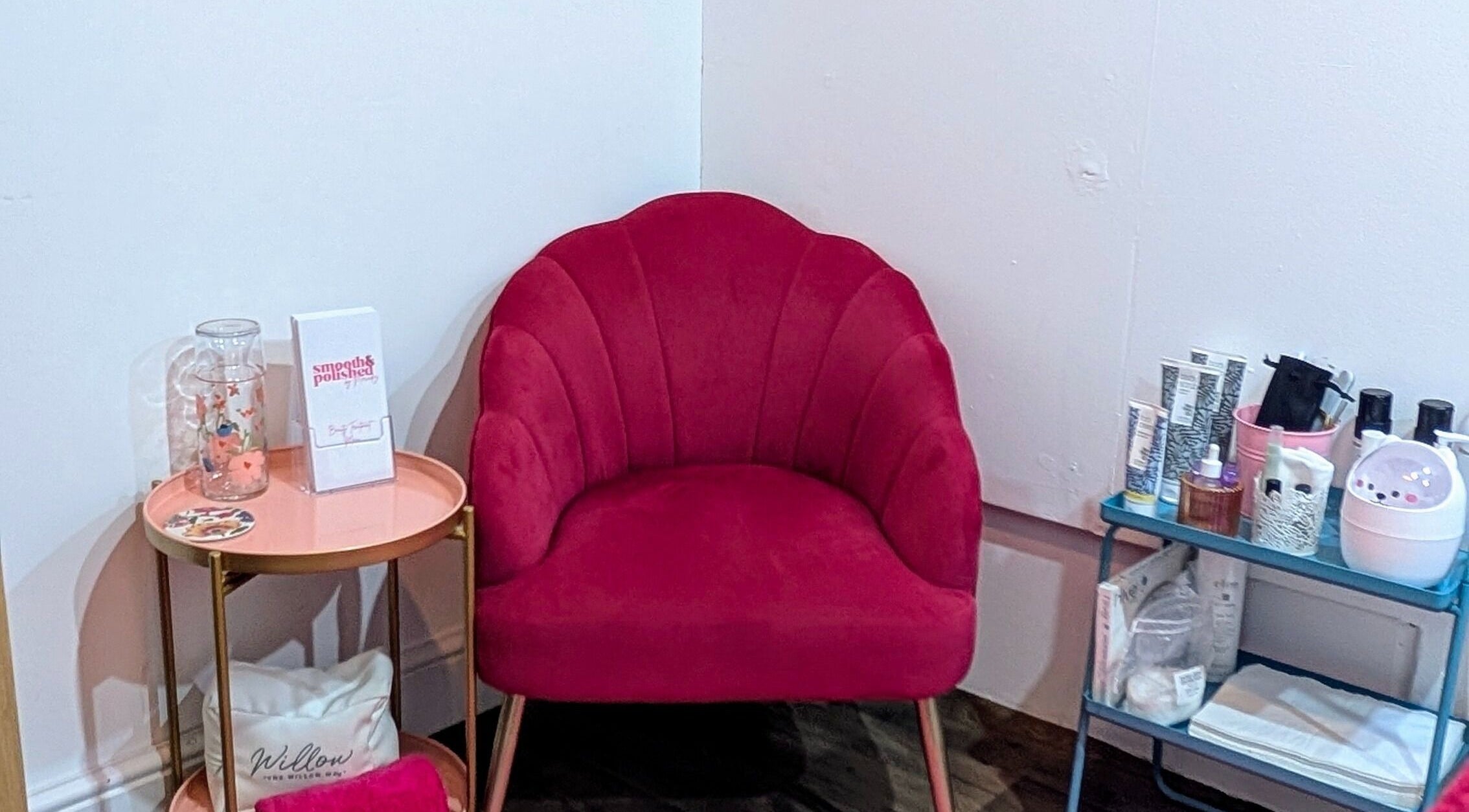 Chic seating area at Smooth & Polished by Mercedez in Swaffham, England, GB highlighting a red velvet chair.