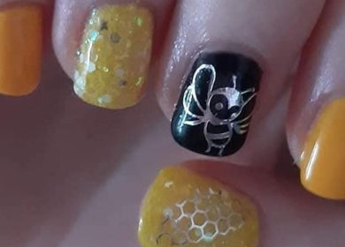 Bee-themed nail art in vibrant yellow and black at Eden Nails & Beauty, Glasgow, GB.