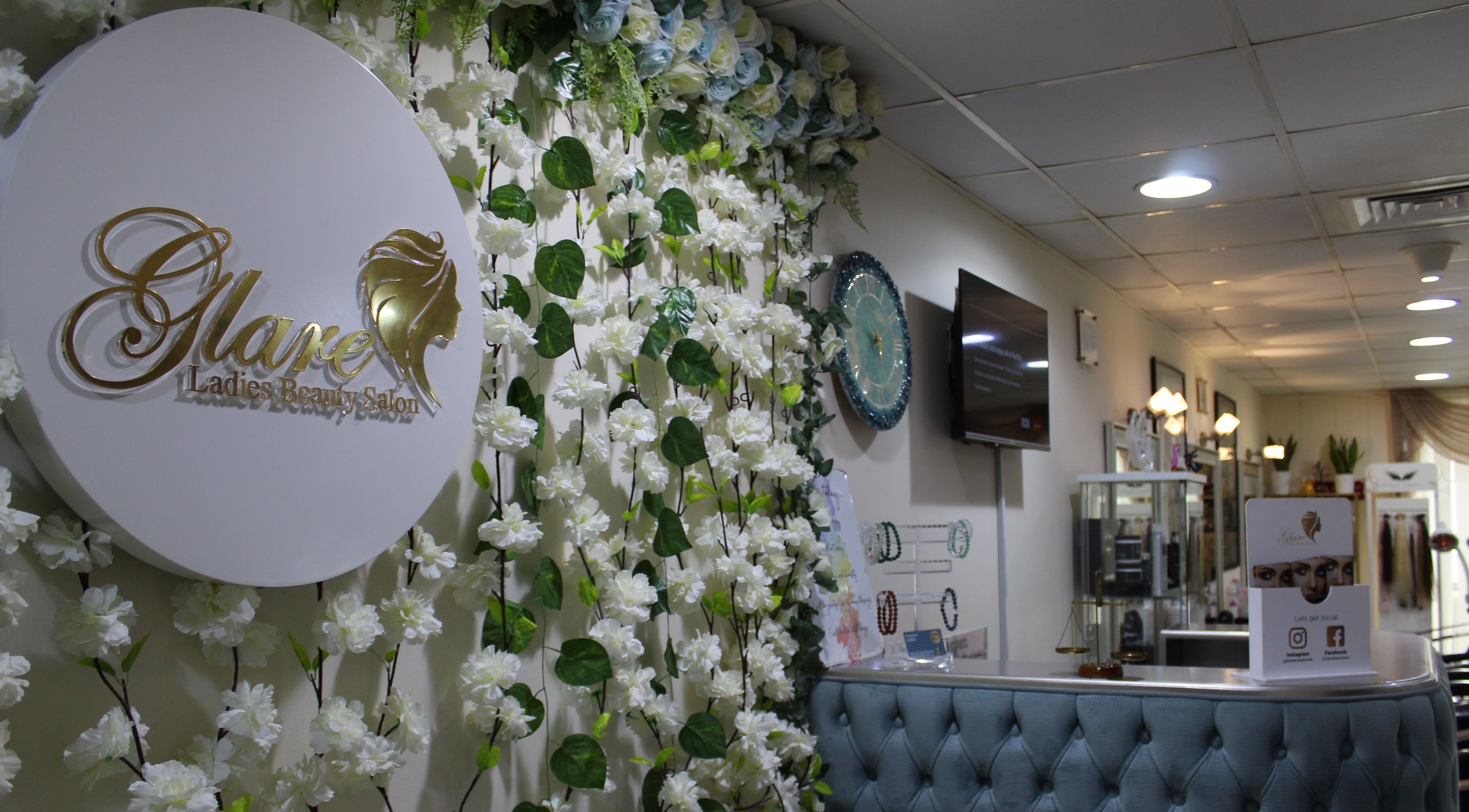 Entrance of Glare Ladies Beauty Salon in Dubai with floral decor and luxurious seating.