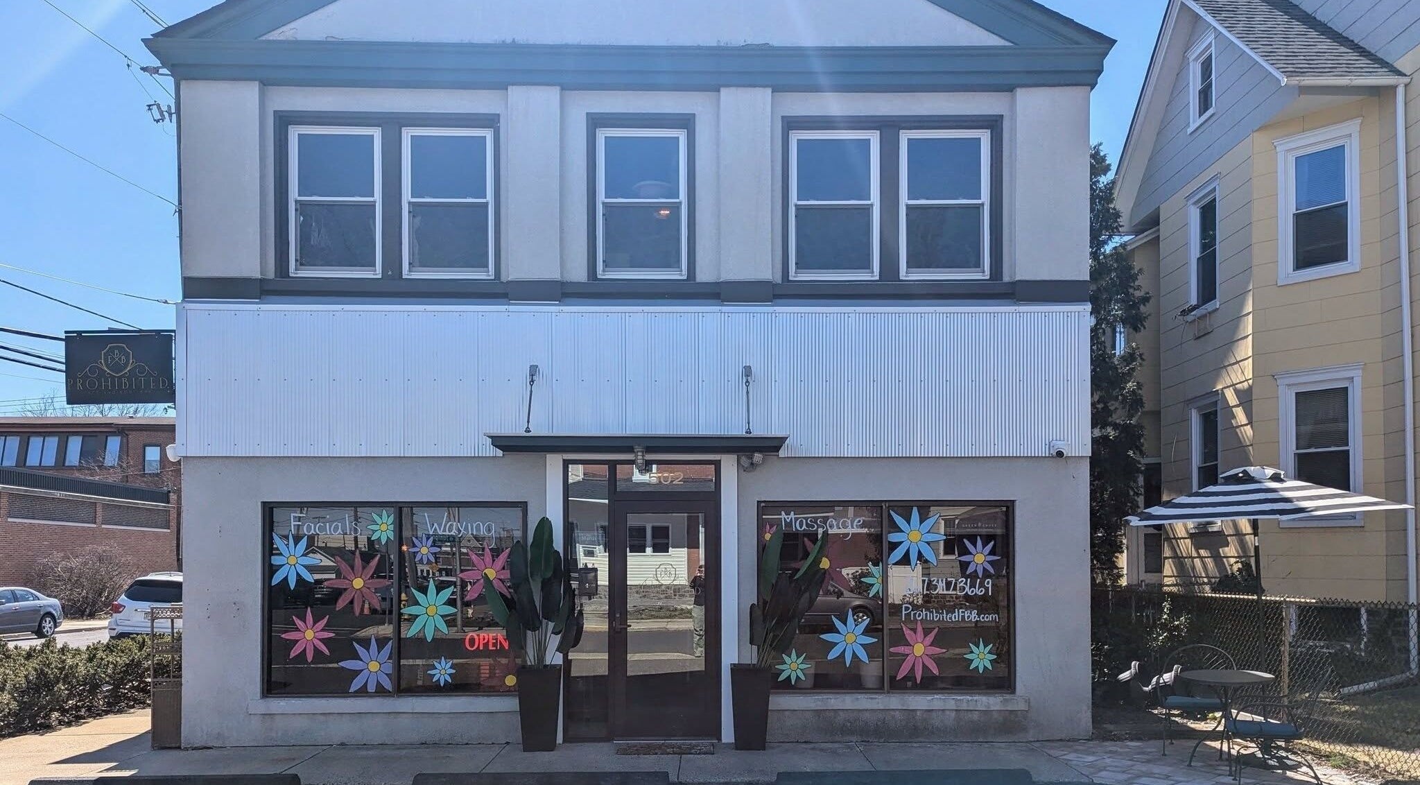 Front view of Prohibited Face and Body Bar in Quakertown, Pennsylvania, US, showcasing colorful window decor.