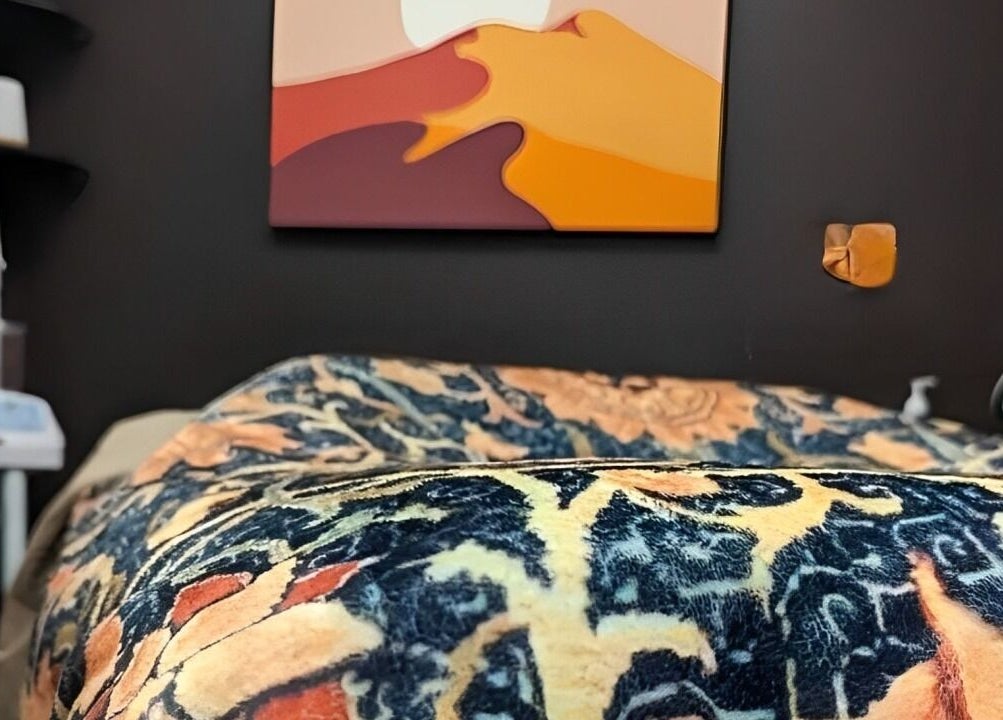 Cozy treatment room at Prohibited Face and Body Bar, Quakertown, Pennsylvania, US with vibrant artwork and plush bedding.