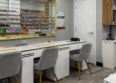 Stylish nail salon interior at Top Nail And Beauty, London, England, GB with elegant seating and polish display.