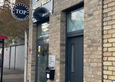 Entrance of Top Nail And Beauty salon in London, England, GB showcasing modern exterior design.