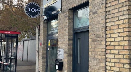 Entrance of Top Nail And Beauty salon in London, England, GB showcasing modern exterior design.