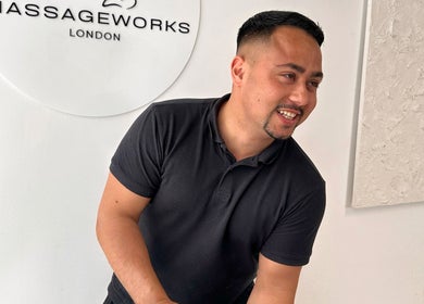 Friendly staff member at TheMassageWorks, London, England, GB, welcoming clients with a smile.