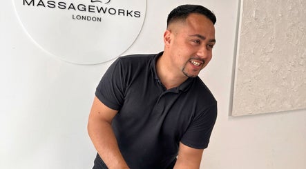 Friendly staff member at TheMassageWorks, London, England, GB, welcoming clients with a smile.