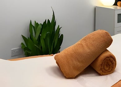 Relaxing massage table setup at TheMassageWorks (Barnet) in London, England, GB, with rolled towels and soothing decor.