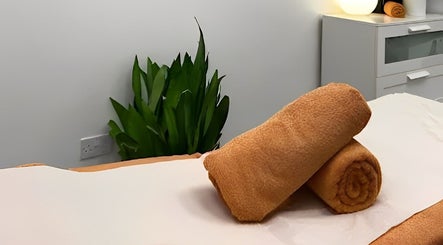 Relaxing massage table setup at TheMassageWorks (Barnet) in London, England, GB, with rolled towels and soothing decor.