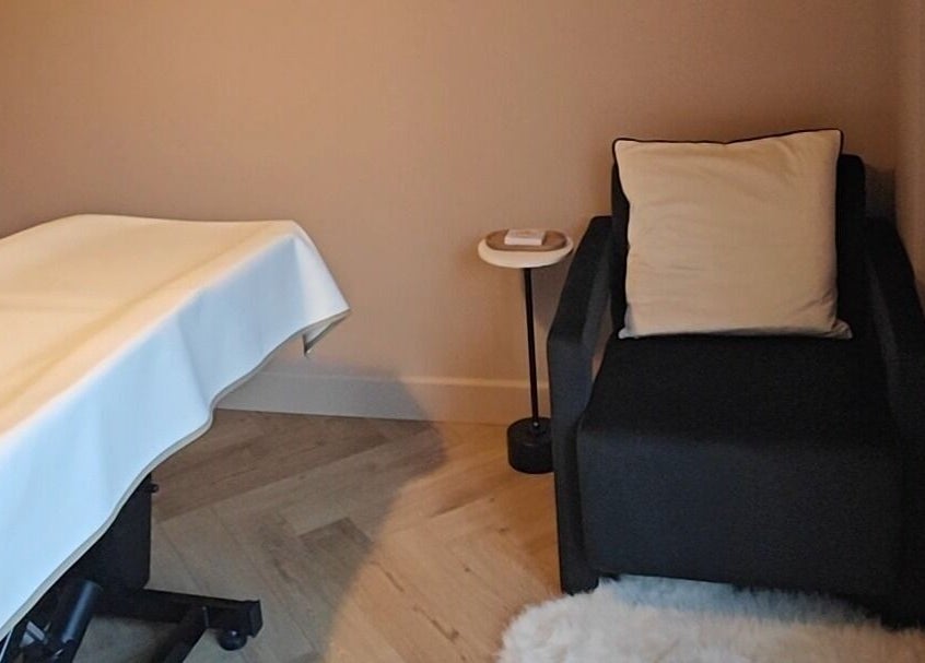 Relaxing treatment room at Coffee Brows and Beauty, Ashford, England, GB, featuring a plush chair and massage table.