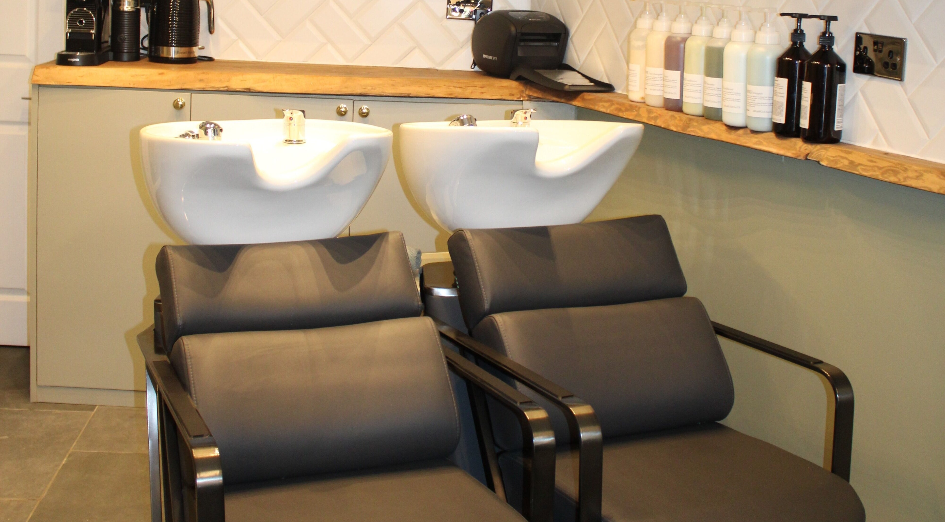 Modern shampoo area at Hair Spring Studio, London, England, GB. Stylish basins and products.