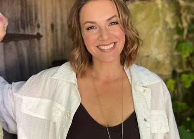 Person smiling warmly at Fig Tree Cabin in Box, England, GB, against a rustic background.